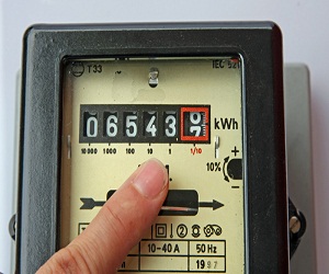 finger of a man indicating the figures in an electric energy meter